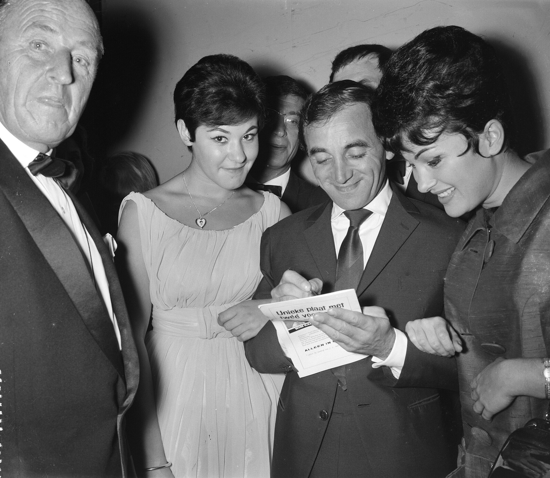 Aznavour signing a record leaflet in a Dutch television studio, 1961