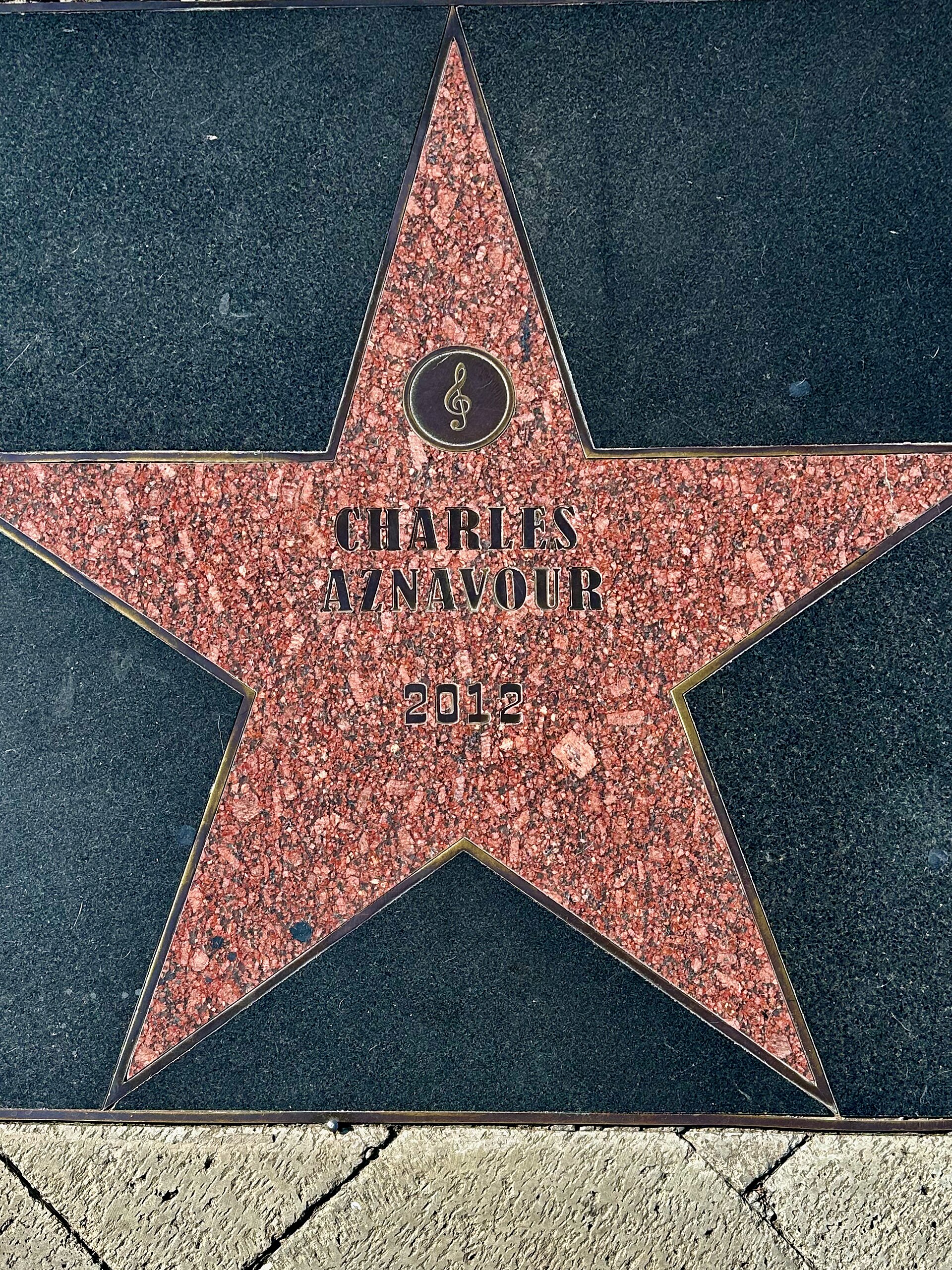 A memorial stone carved with the name Charles Aznavour and the year 2012